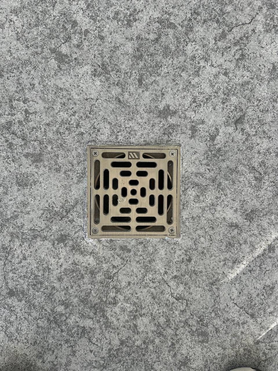A drain set flush into textured membrane