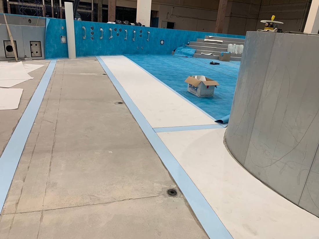A textured membrane strip along the edge of a pool deck
