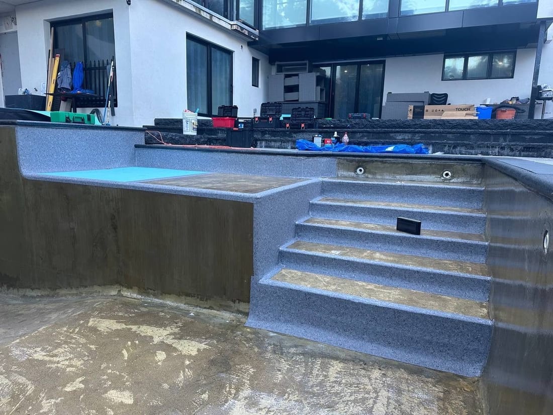 Pool steps wrapped in grey membrane, the seams welded on site