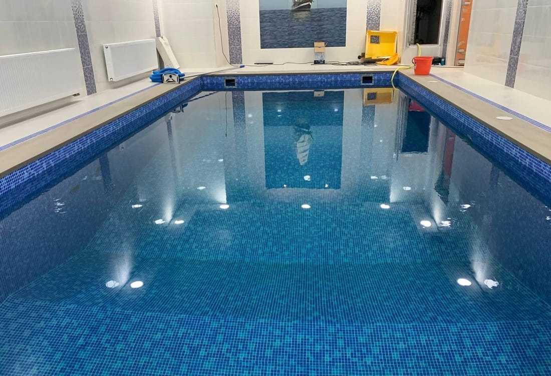 An indoor pool in blue mosaic-pattern membrane with the underwater lights on