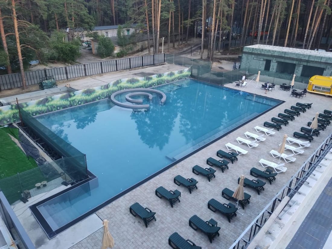 A resort pool seen from above, with rows of loungers beside it